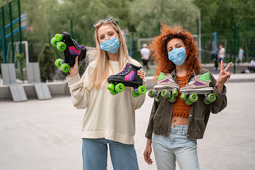 young roller skaters in medical masks  outdoors