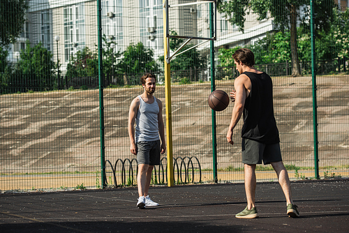 Men in sportswear playing basketball on court