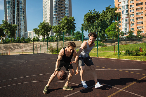 Young men training while playing basketball on playground