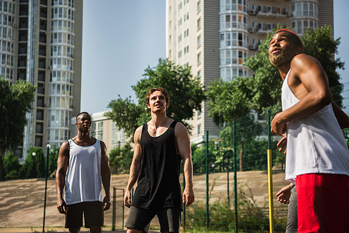 Positive interracial sportsmen looking away outdoors
