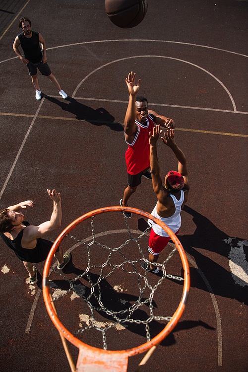 Overhead view of interracial men playing basketball near hoop