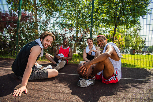 Happy multiethnic sportsmen  on basketball playground