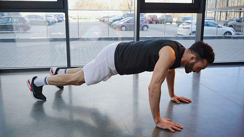 Side view of sportsman doing press ups in gym