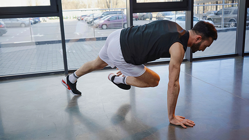 Side view of athletic sportsman training in gym