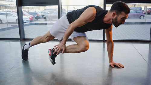 Side view of brunette sportsman working out in gym