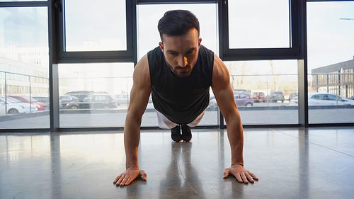 Brunette sportsman standing in plank in gym