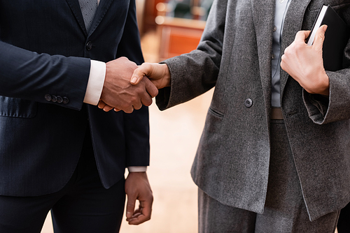 partial view of businessman and advocate shaking hands in court