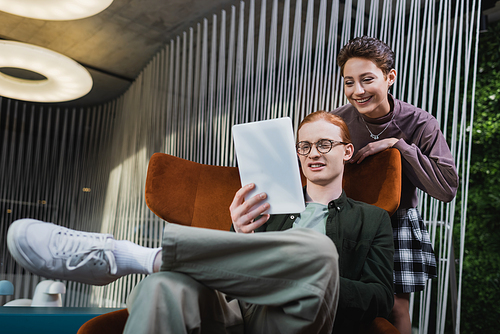 Smiling couple using digital tablet in hotel lobby