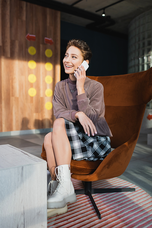 Smiling woman talking on cellphone in hotel lobby