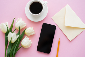 top view of white tulips near smartphone with blank screen and cup of coffee on pink