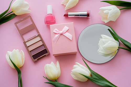top view of white flowers, gift box and decorative cosmetics on pink