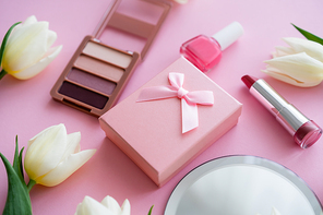 close up of white flowers, gift box and decorative cosmetics on pink