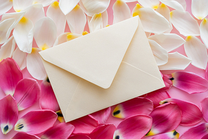 top view of envelope on white and pink floral petals