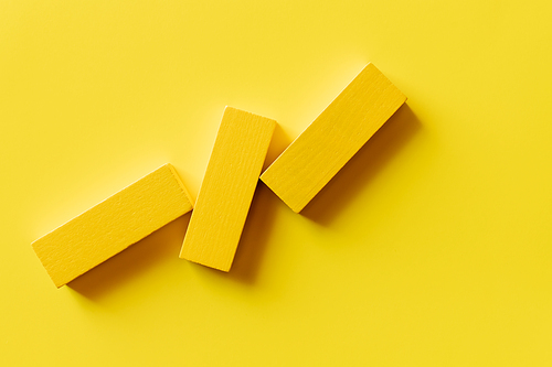 top view of three colorful blocks on yellow background