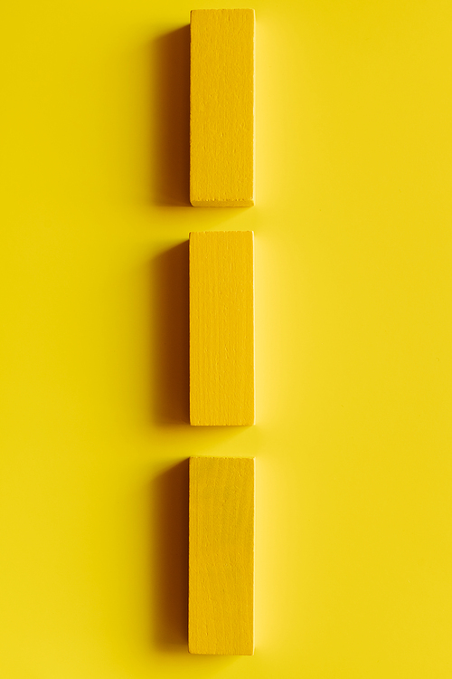 top view of colored blocks in vertical line on yellow background
