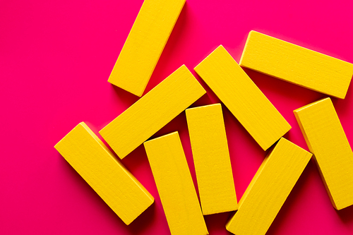 top view of several yellow blocks on bright pink background