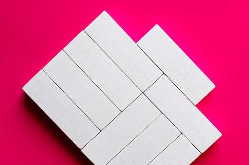 top view of white rectangular shape blocks on pink background