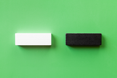 top view of two white and black blocks on green background