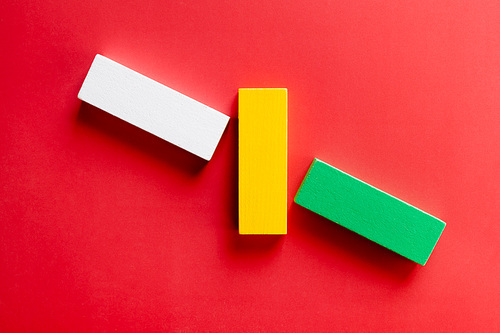 top view of green, white and yellow blocks on red background