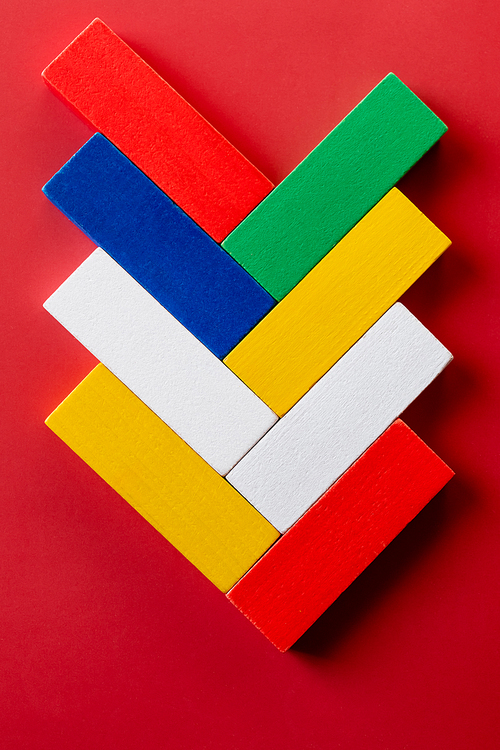 top view of bright multicolored rectangular blocks on red background