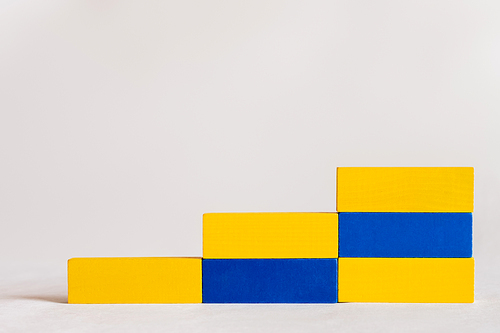 stairs made of rectangular blue and yellow blocks on white background, ukrainian concept