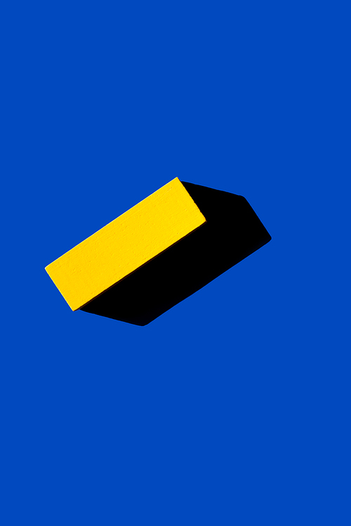 top view of yellow rectangular block on blue background, ukrainian concept