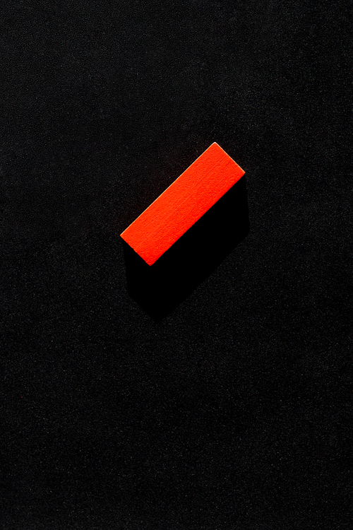 top view of bright red block on black background with copy space