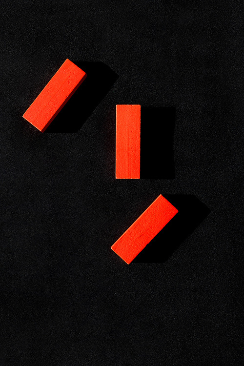 top view of three red blocks on black background