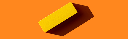 top view of yellow rectangular block on orange background with shadow, banner