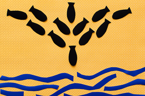 Top view of paper bombs and carton sea on textured yellow background