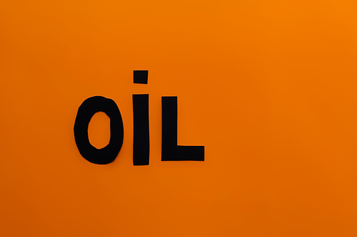 Top view of paper oil word on orange background
