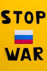 Top view of russian flag and stop war lettering on yellow background