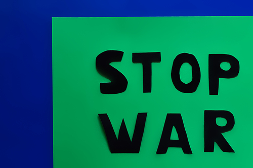 Top view of stop war paper lettering on green and blue background