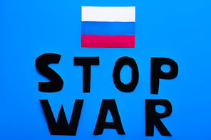 Top view of russian flag and stop war lettering on blue background