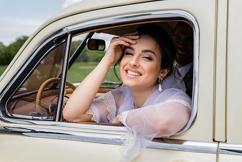 Happy bride  near window of vintage auto