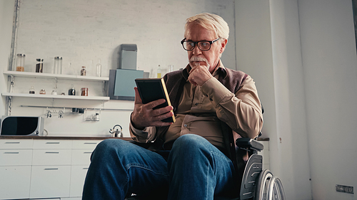 disabled senior man in wheelchair holding photo frame