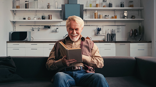 happy senior man reading book at home