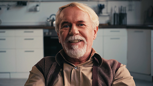happy and bearded pensioner smiling while 