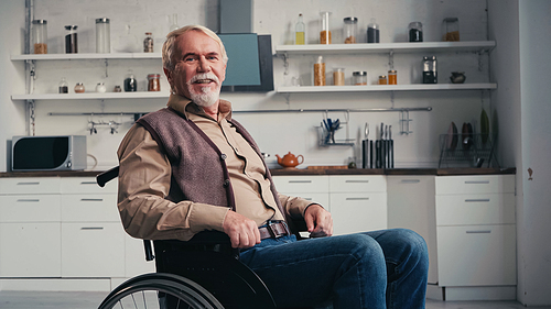 . pensioner smiling while sitting in wheelchair