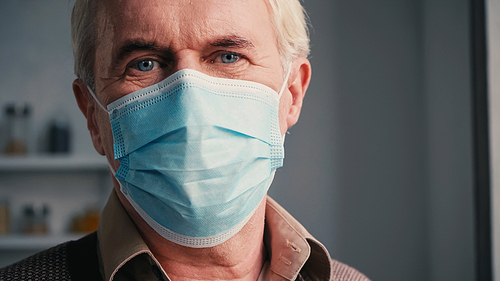 close up of senior man with blue eyes in medical mask