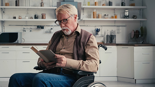 disabled senior man in wheelchair reading book
