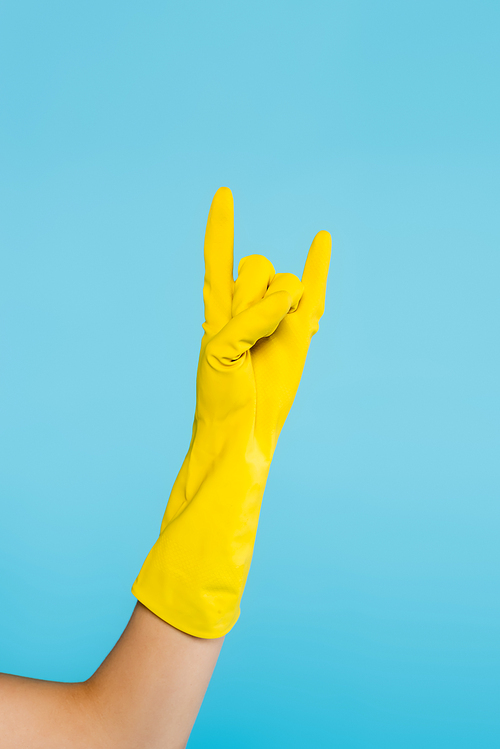 cropped view of woman in yellow rubber glove showing rock sign isolated on blue