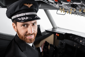 cheerful pilot in cap  in airplane simulator