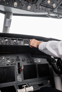 cropped view of pilot reaching control panel in airplane