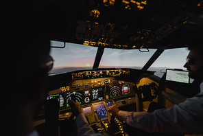 blurred professionals piloting airplane in evening during sunset