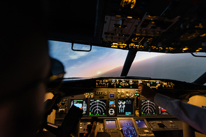 partial view of professionals piloting airplane in evening