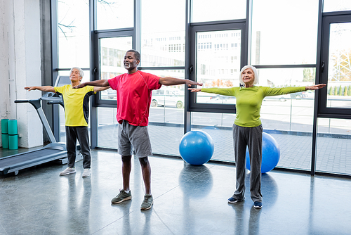 Interracial elderly people training together in sports center