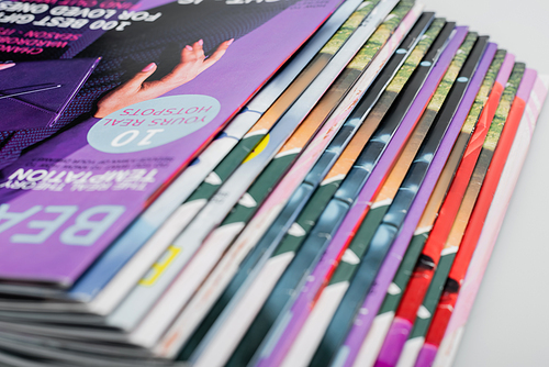 close up view of colorful magazines collection isolated on grey