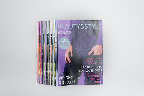 top view of colorful beauty and style magazines isolated on grey