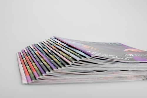 stack of blurred magazines on grey background